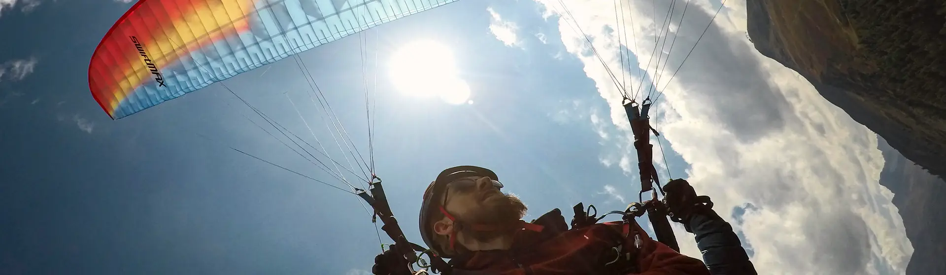 Tandem-Gleitschirm bei einem Freestyle-Manöver hoch über dem Tal von Davos