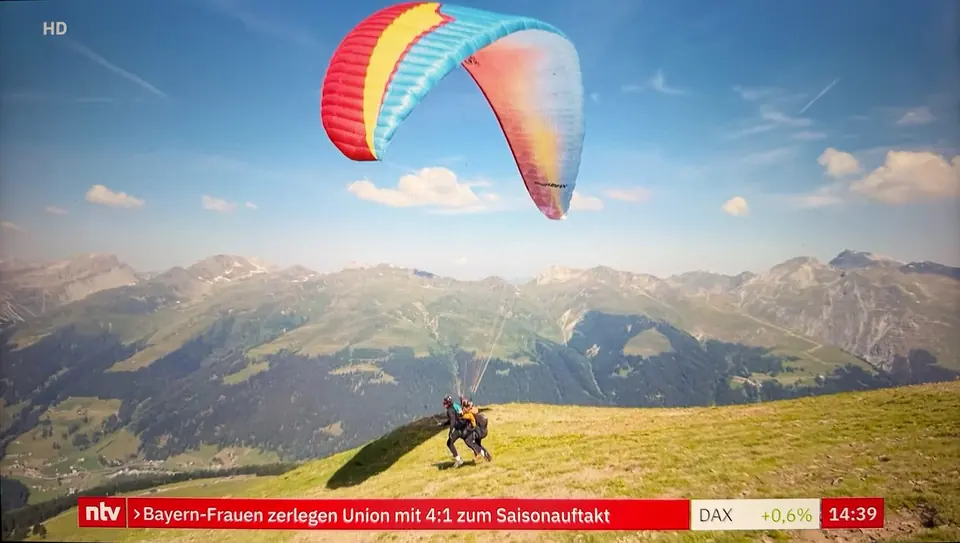Air-Davos-Tandemgleitschirm über den Bergen von Davos, gezeigt im n-tv-Reisebeitrag